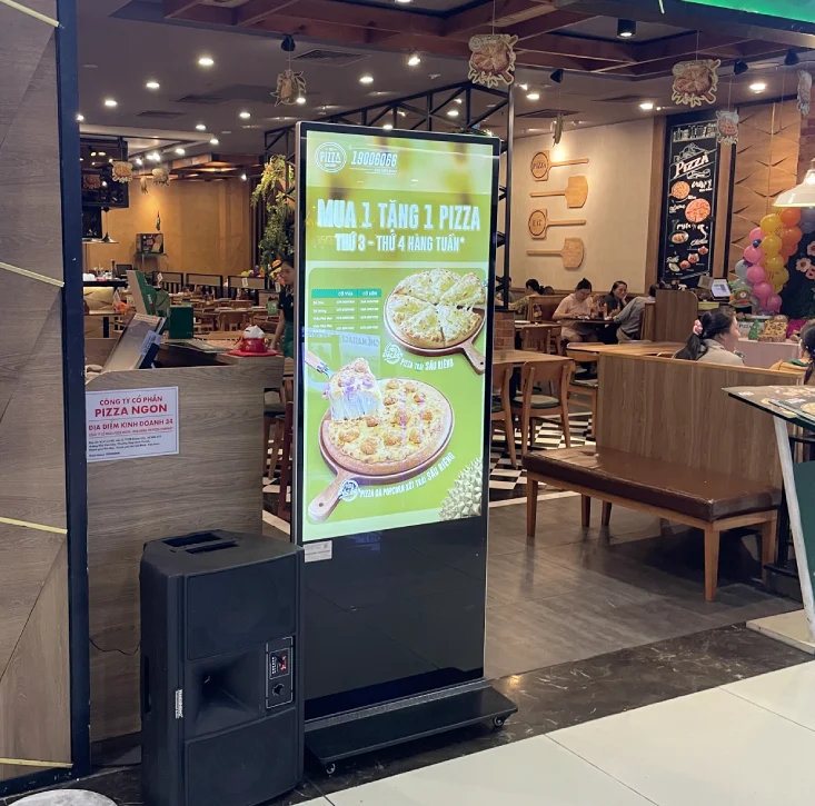 màn hình quảng cáo LCD chân đứng để phía trước cửa hàng pizza